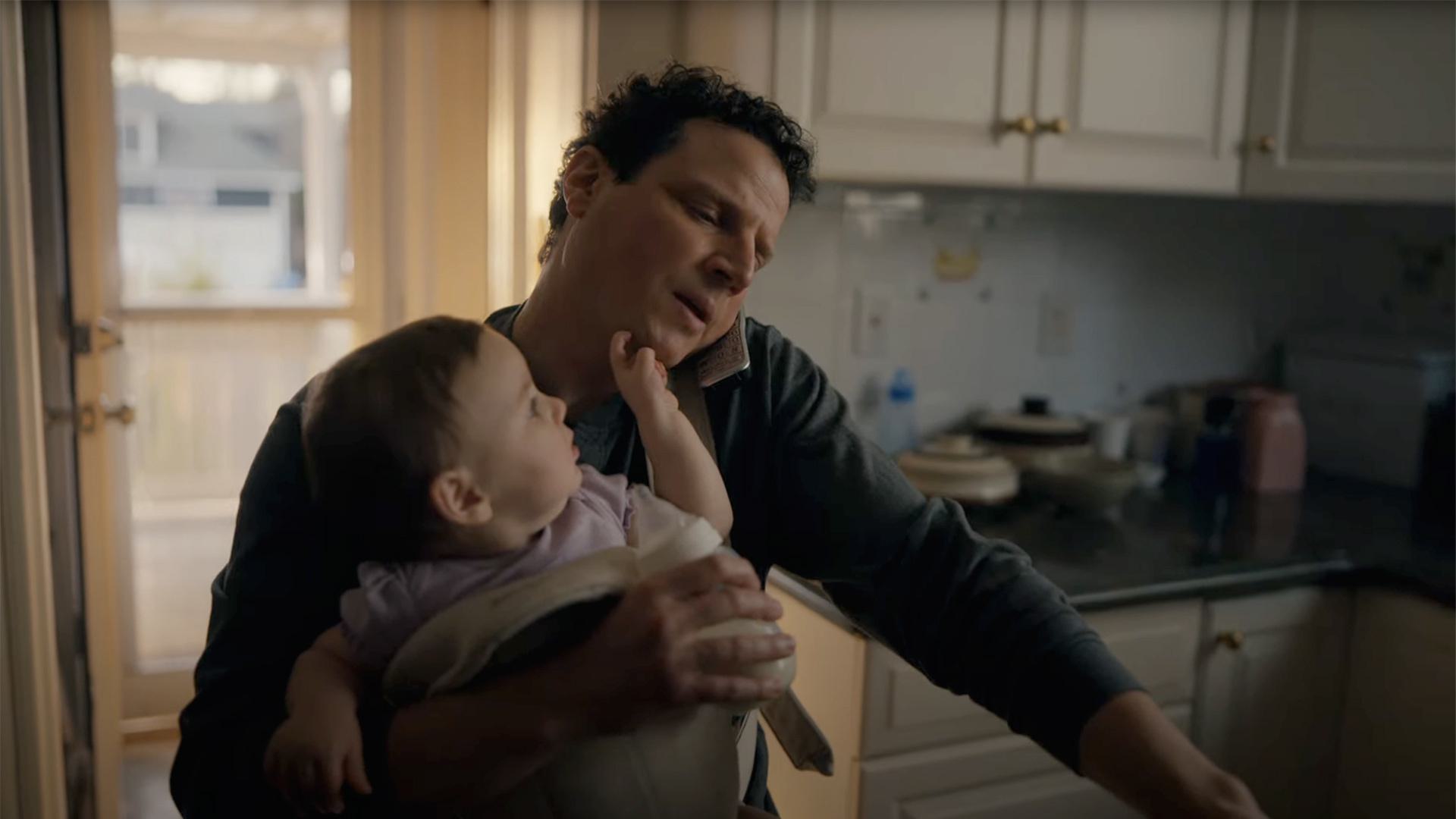 dad holds baby while on the phone