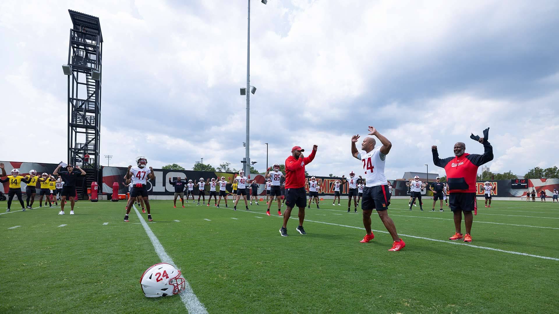 Gov. Wes Moore does jumping jacks with the Maryland Terrapins football team