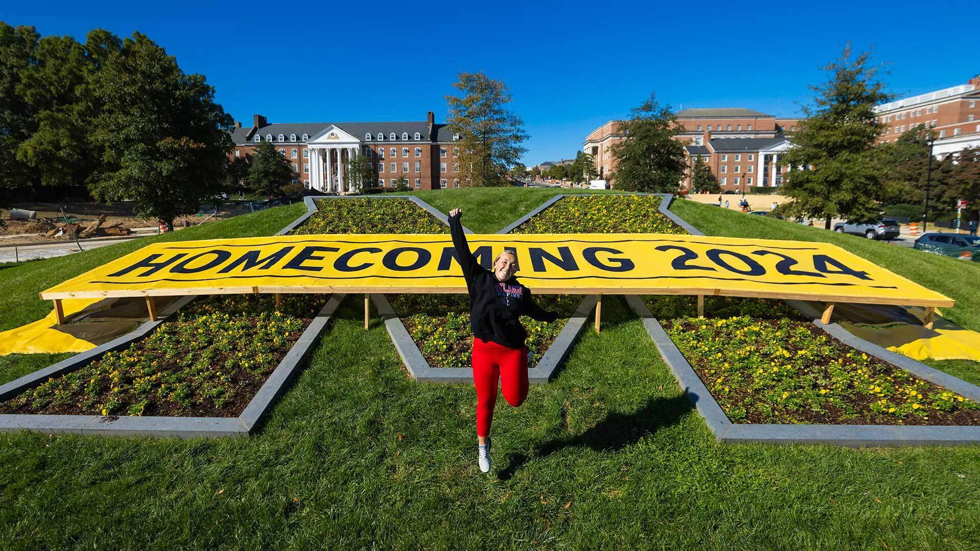 Person jumps in front of Maryland M planting