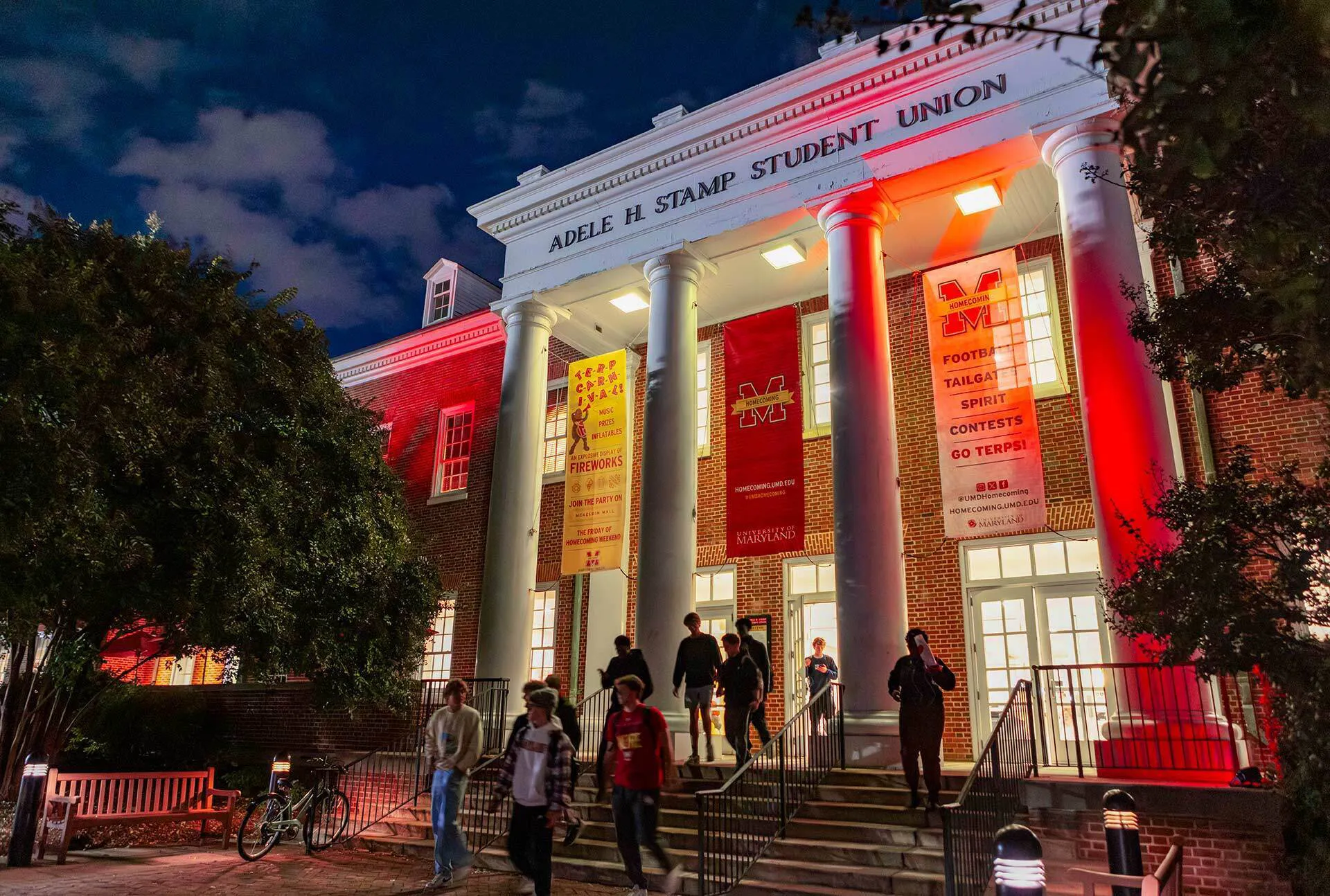 people walk out of a building lit up with red lights