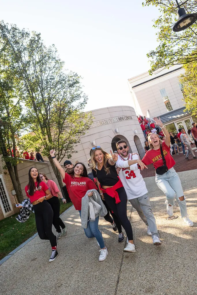students wearing Maryland gear cheer outside Riggs Alumni Center