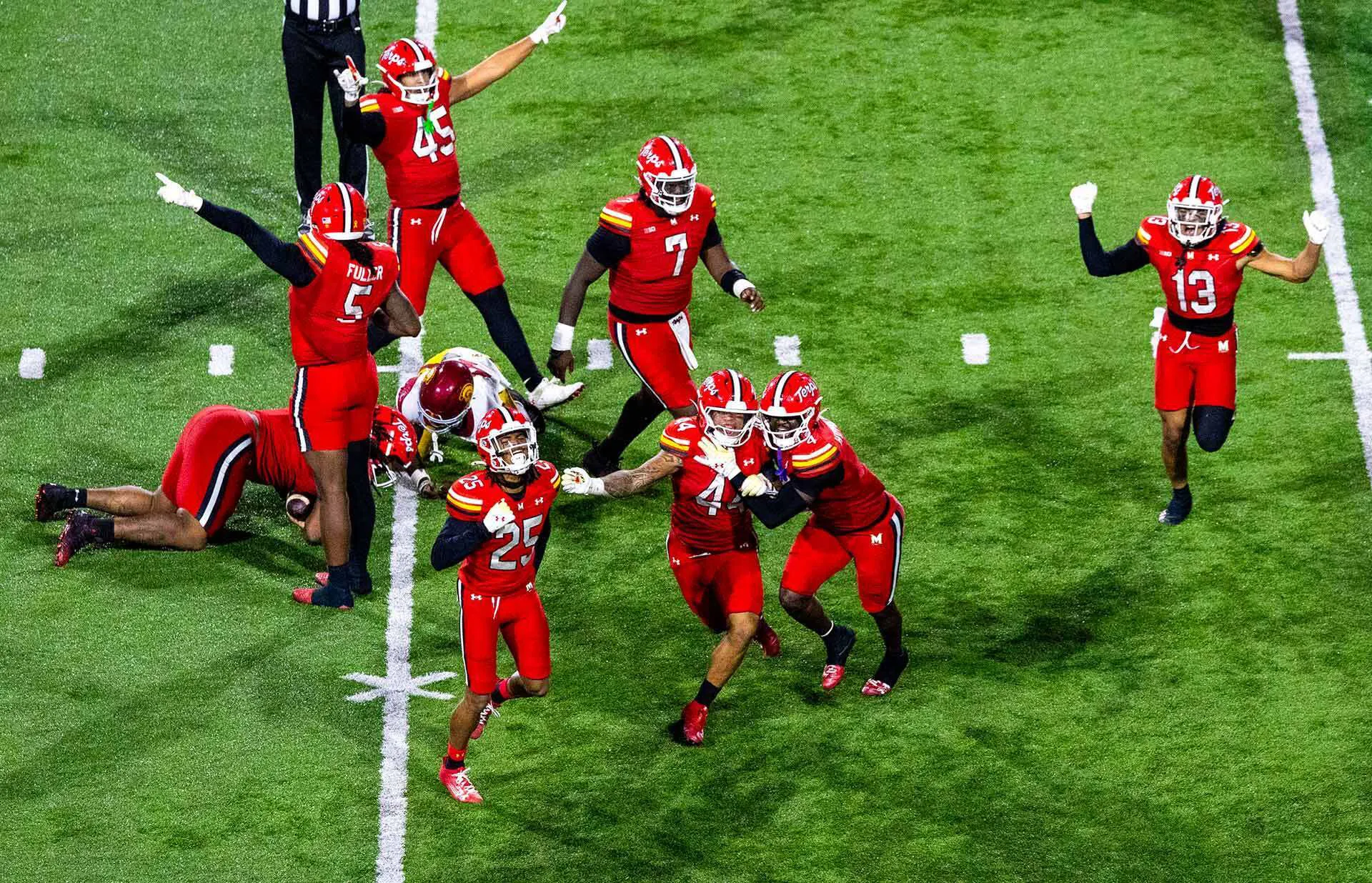 Maryland players run around celebrating on football field