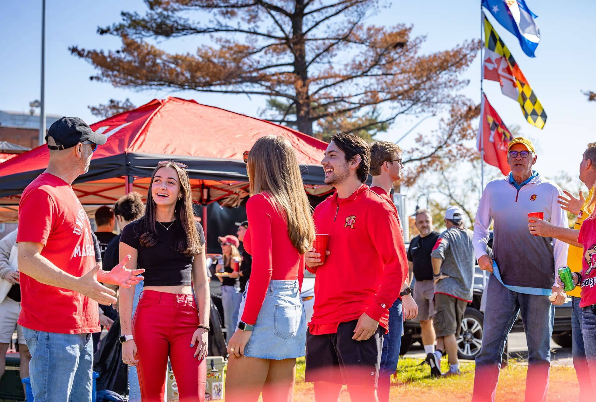 people stand around at a tailgate party
