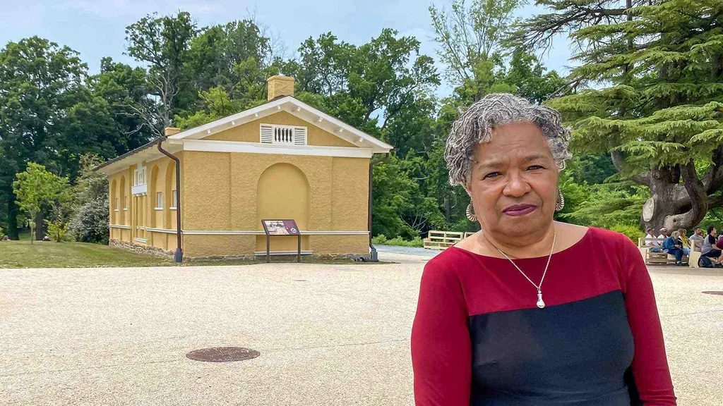 Cheryl Laroche stands in front of slave quarters at Arlington House