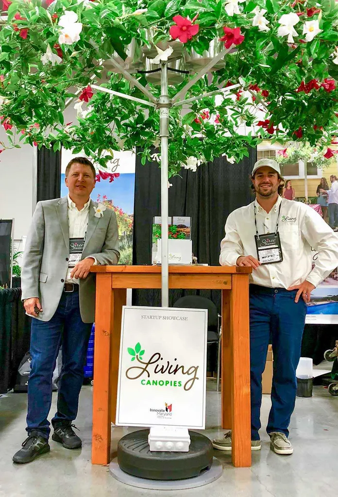 Professor David Tilley and Nick Cloyd ’13, M.S. ’17 pose under Living Canopy umbrella