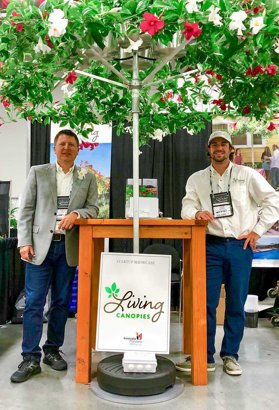Professor David Tilley and Nick Cloyd ’13, M.S. ’17 pose under Living Canopy umbrella