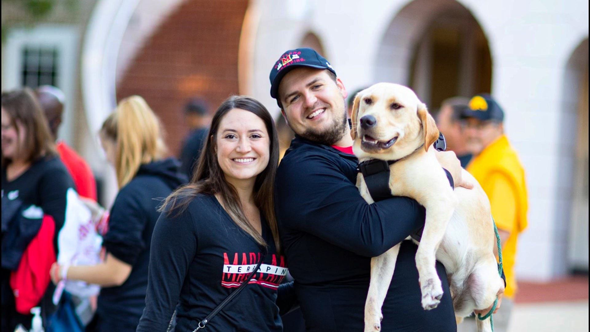 Joe Oudin '14 and Liz Wasden Oudin '15 hold yellow Lab
