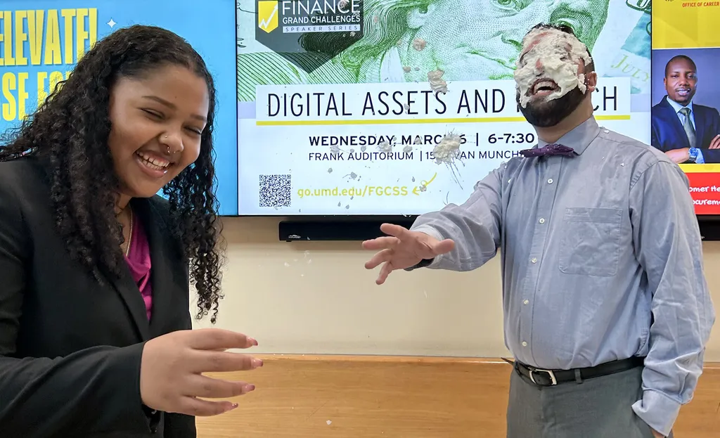 woman laughs as man gets pied in face