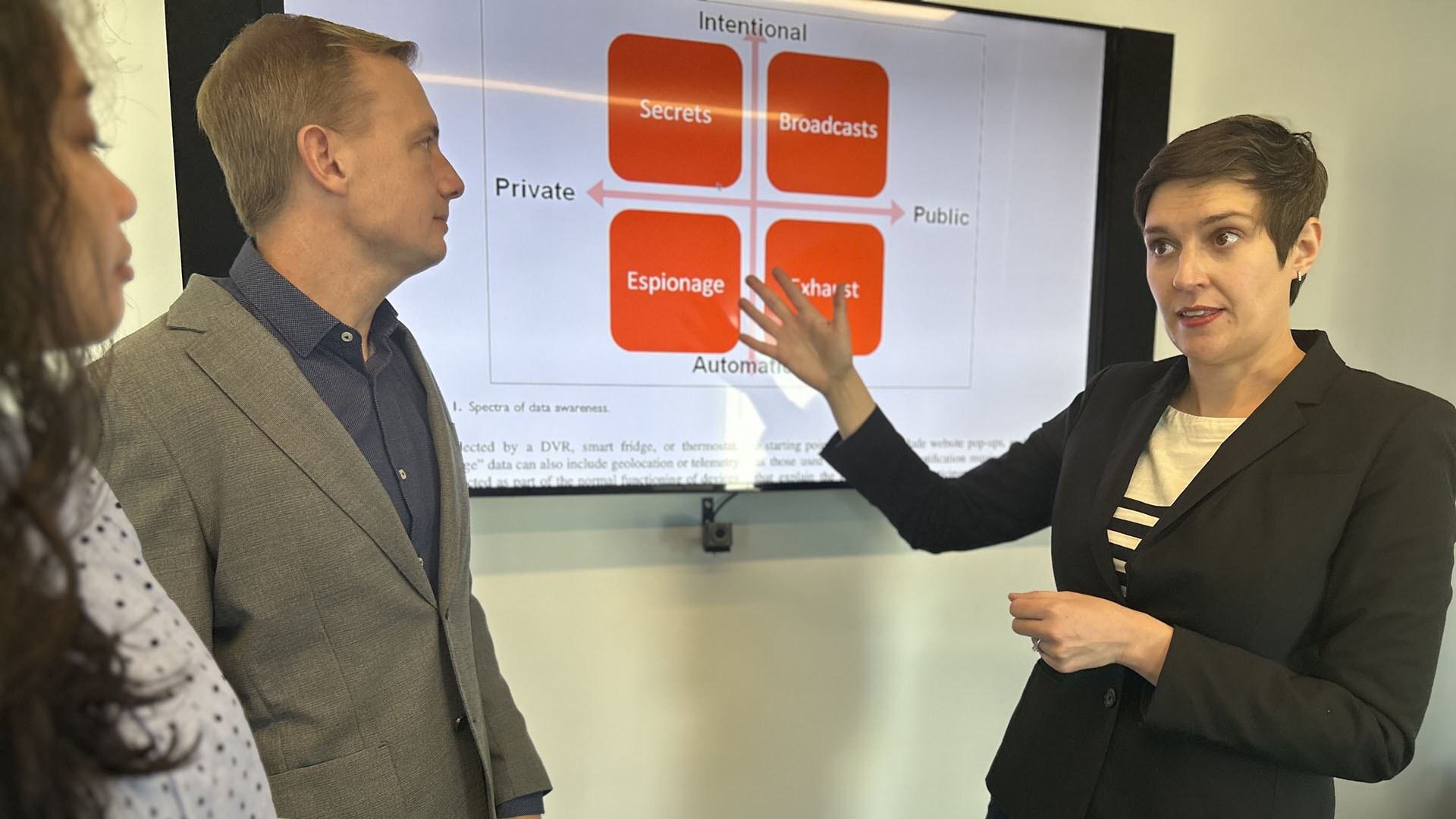 researchers gesture toward chart on screen