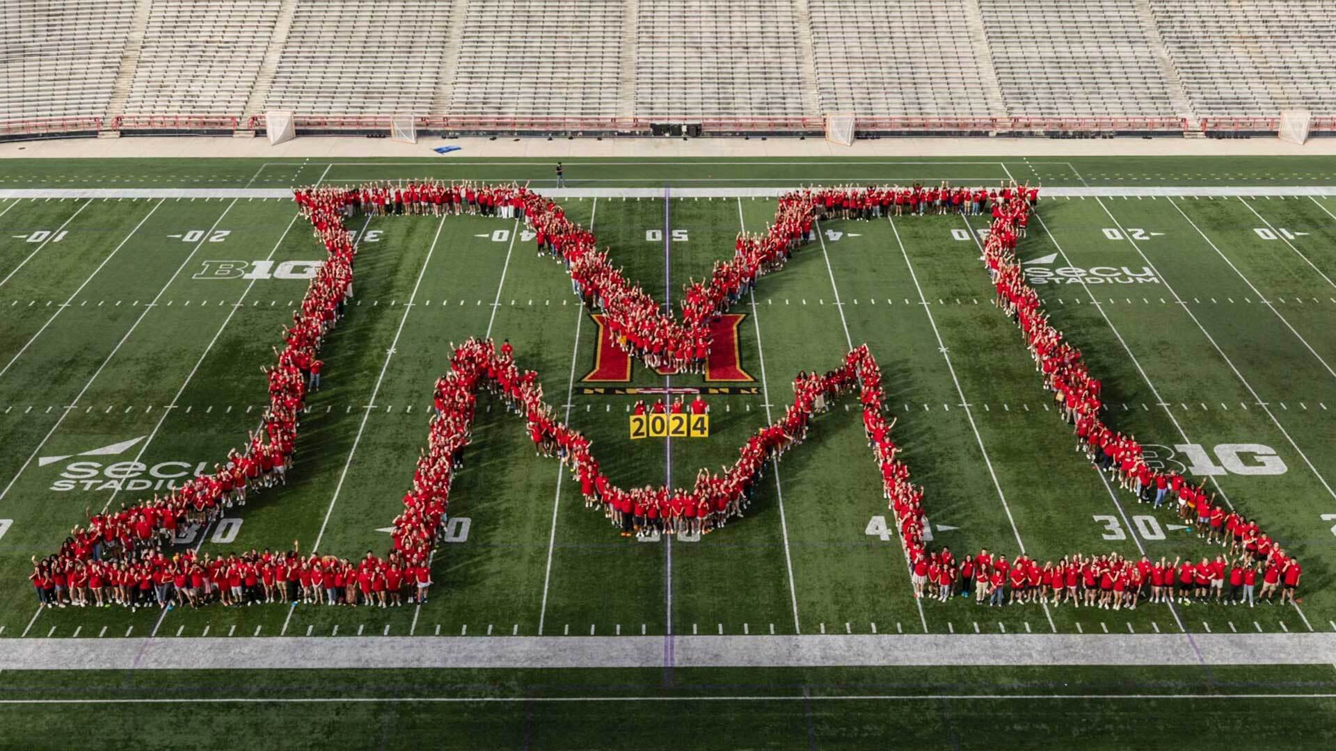 large M made of people on football field