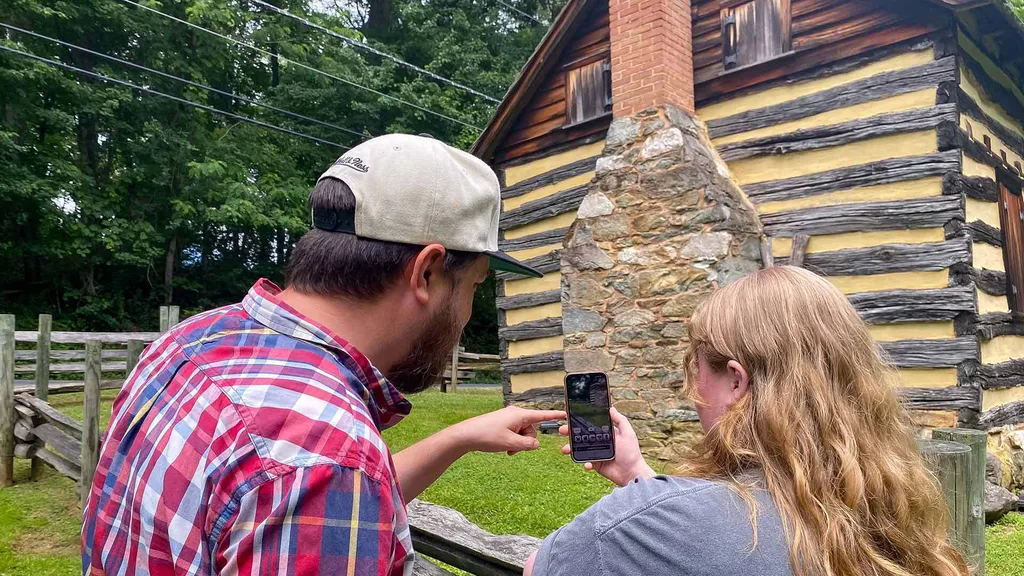 two people look at smartphone near cabin