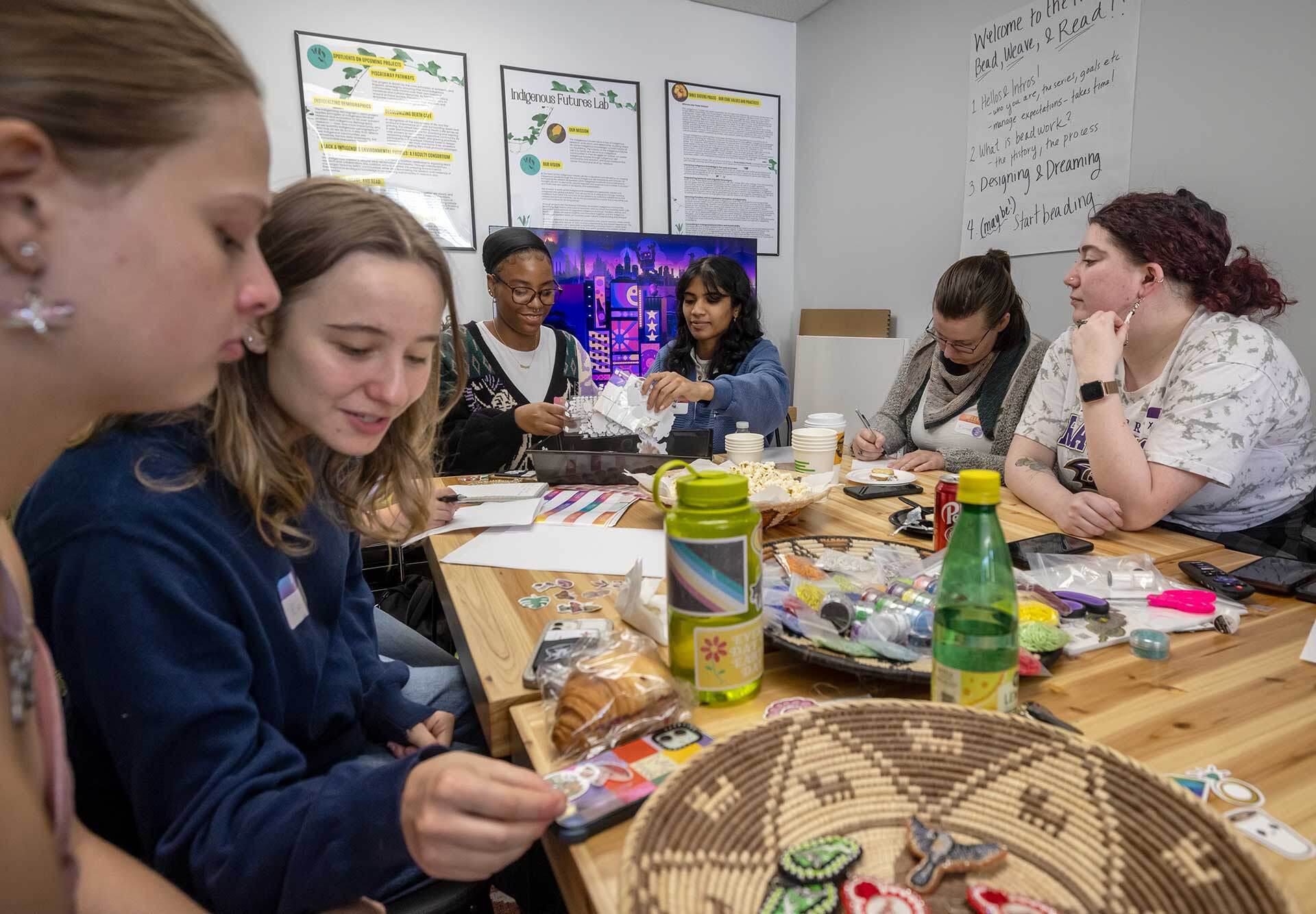 students gathered around a table with woven baskets and crafting materials
