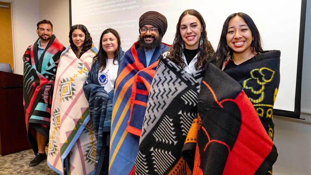 six students with blankets draped around them