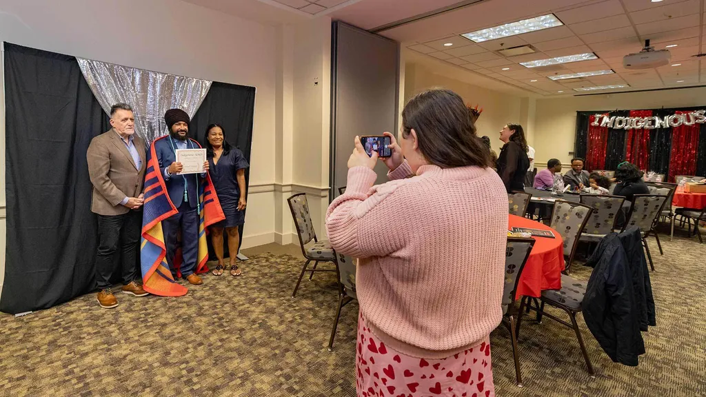 woman takes photo of student with parents