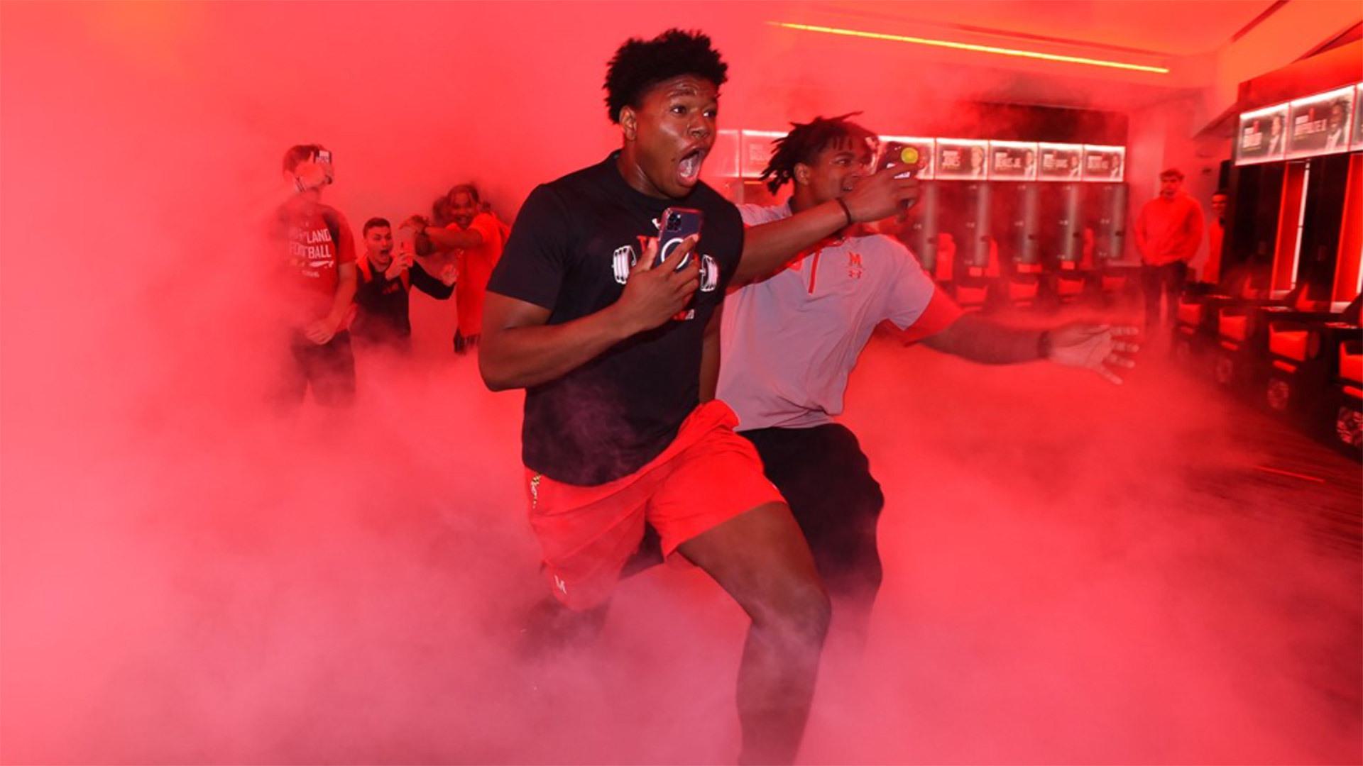 Football players run into red-lit Jones-Hill House locker room