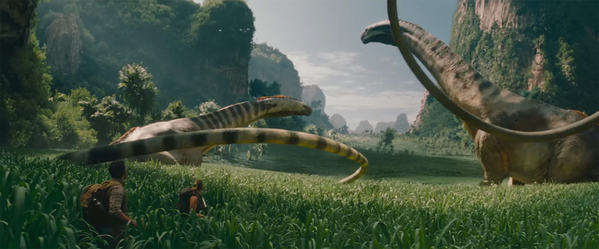 Two people watch plant-eating dinosaurs with long whiplash tails amidst tall grasses and cliffs