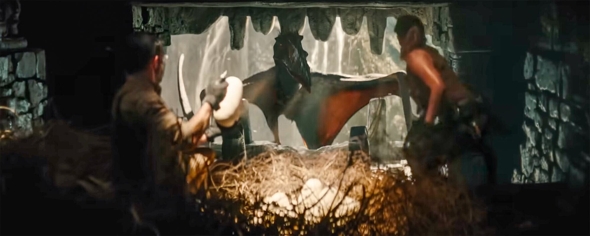 Two people face a giant flying dinosaur by its nest full of eggs