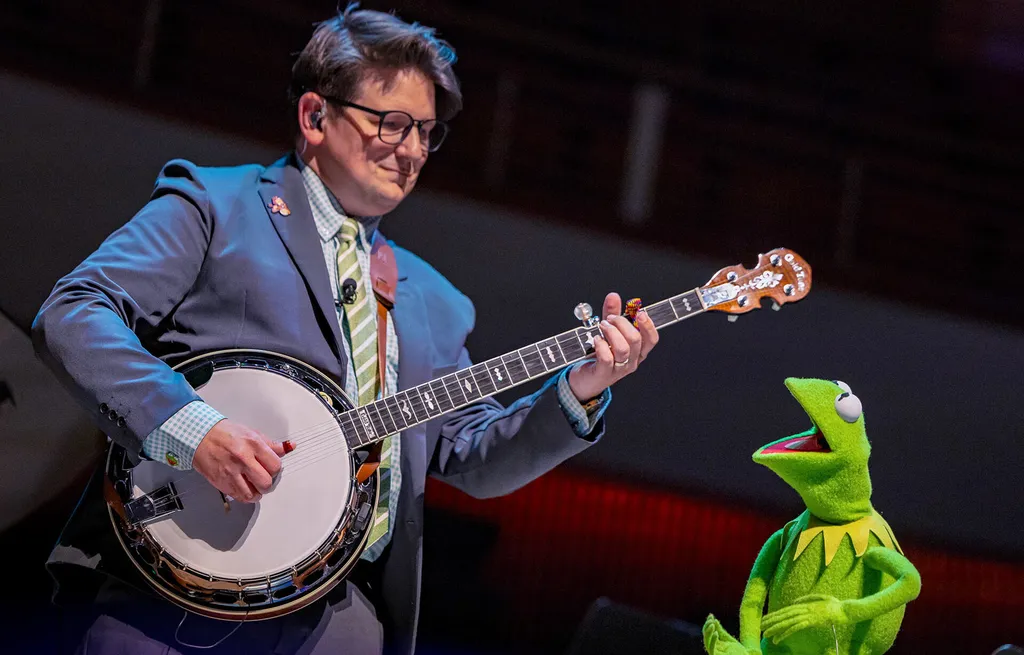 man plays banjo while kermit the frog sings