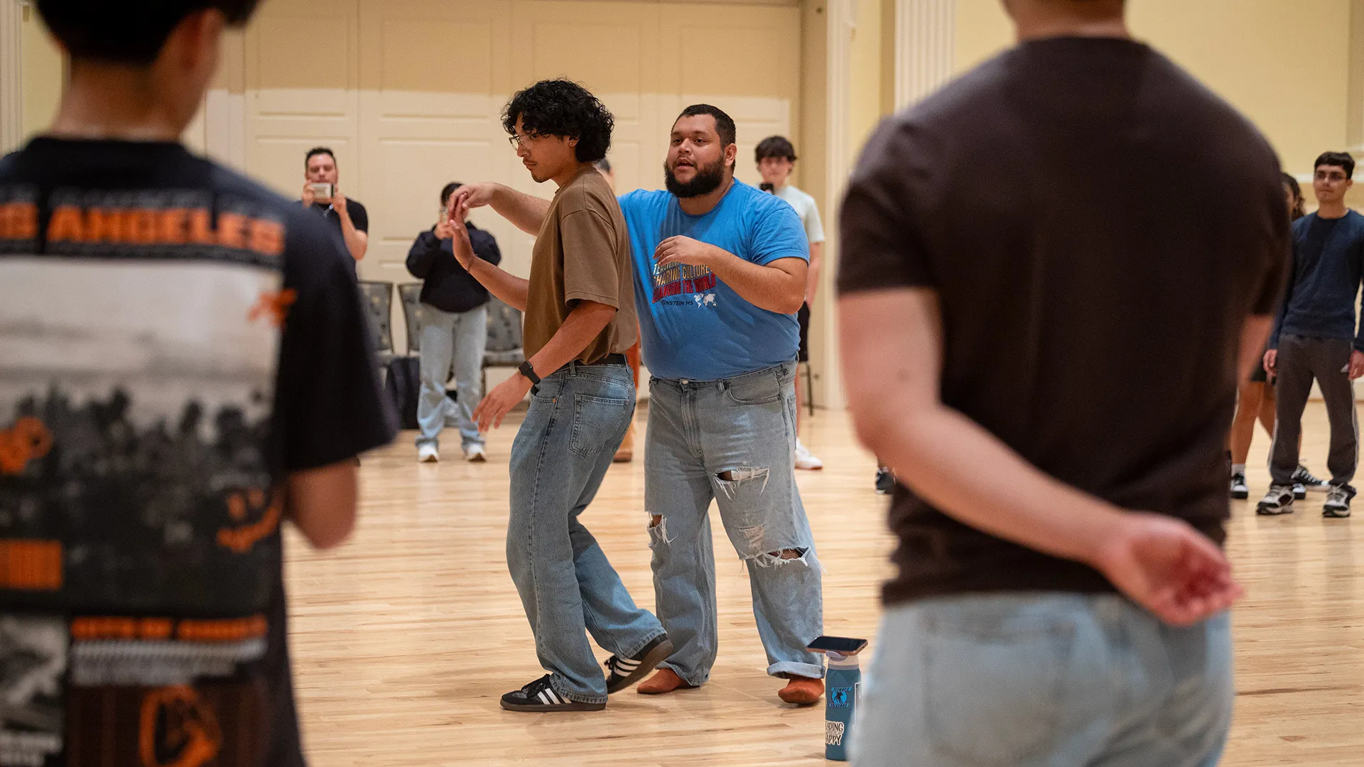 A man spins another person to demonstrate a bachata dance move.