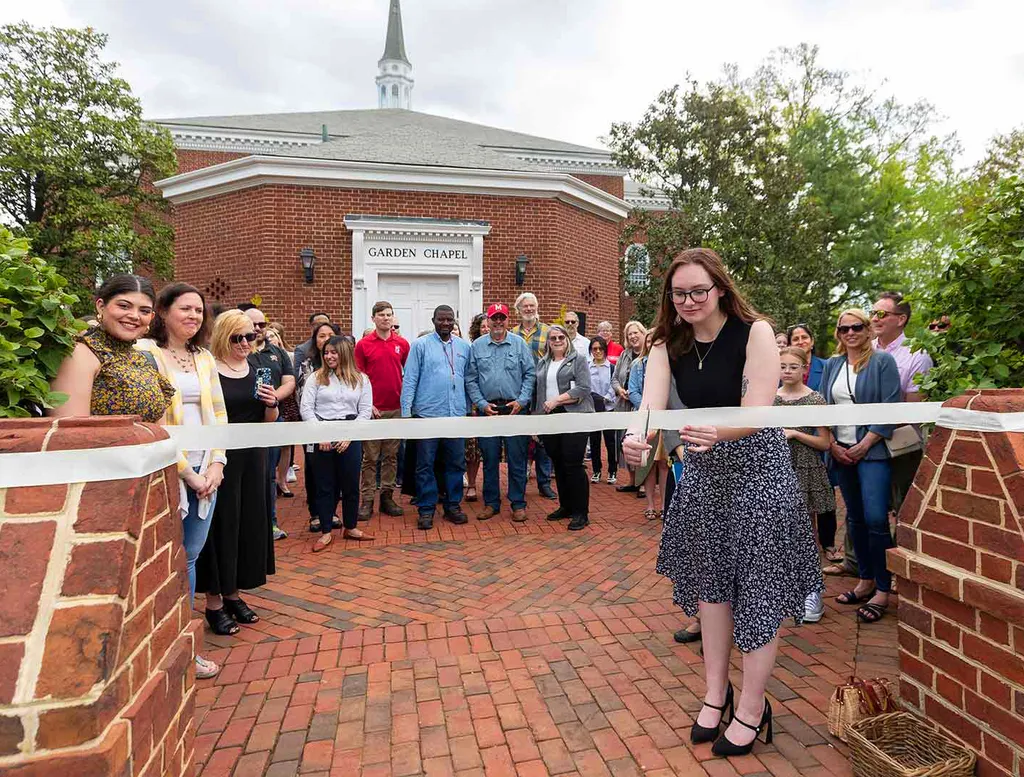 woman cuts ribbon at Listening Garden dedication ceremony