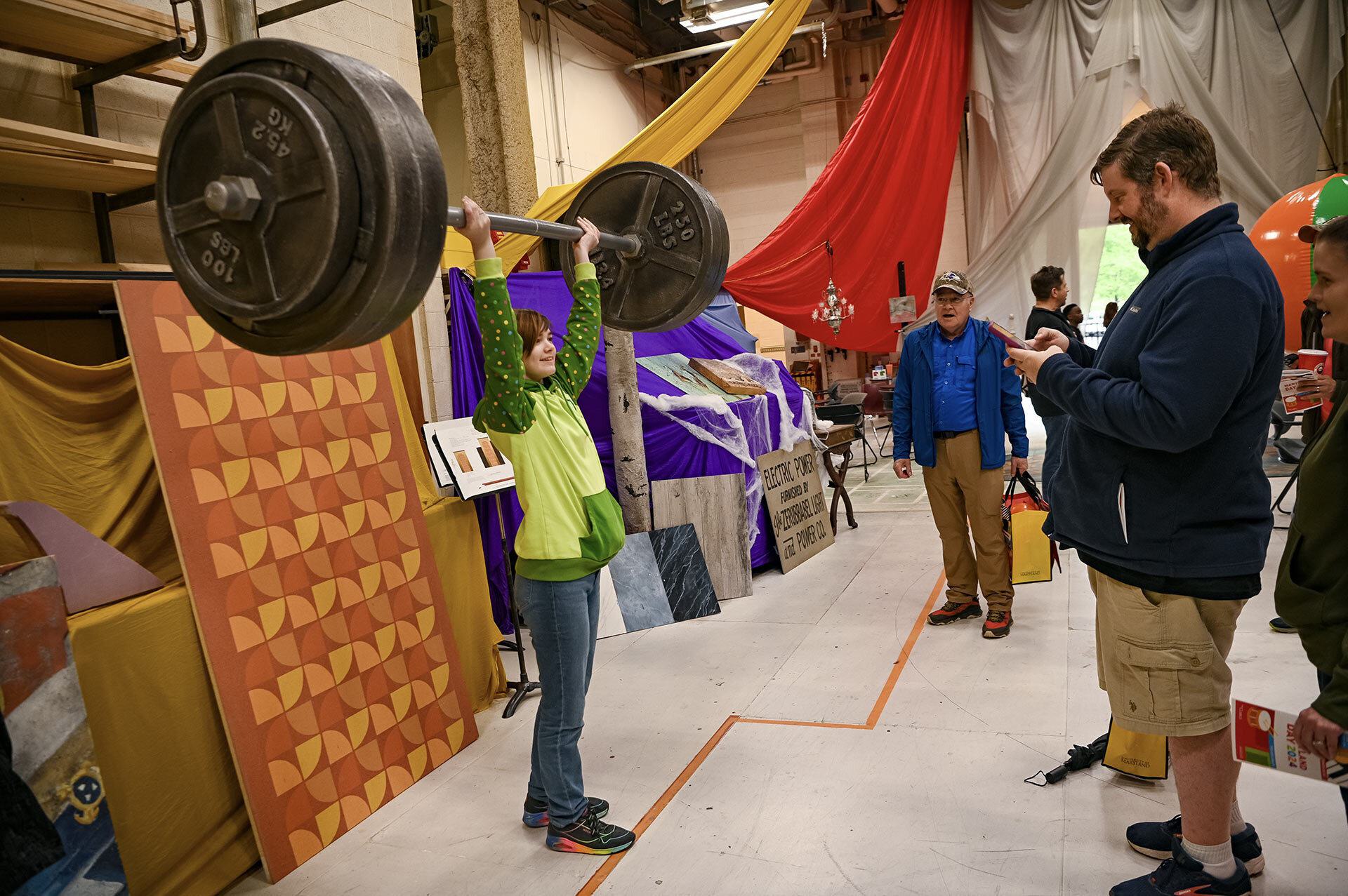 person lifts giant weight prop