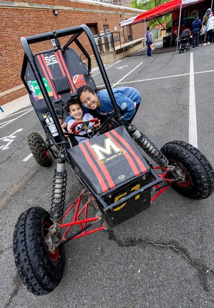 people pose in a small race car