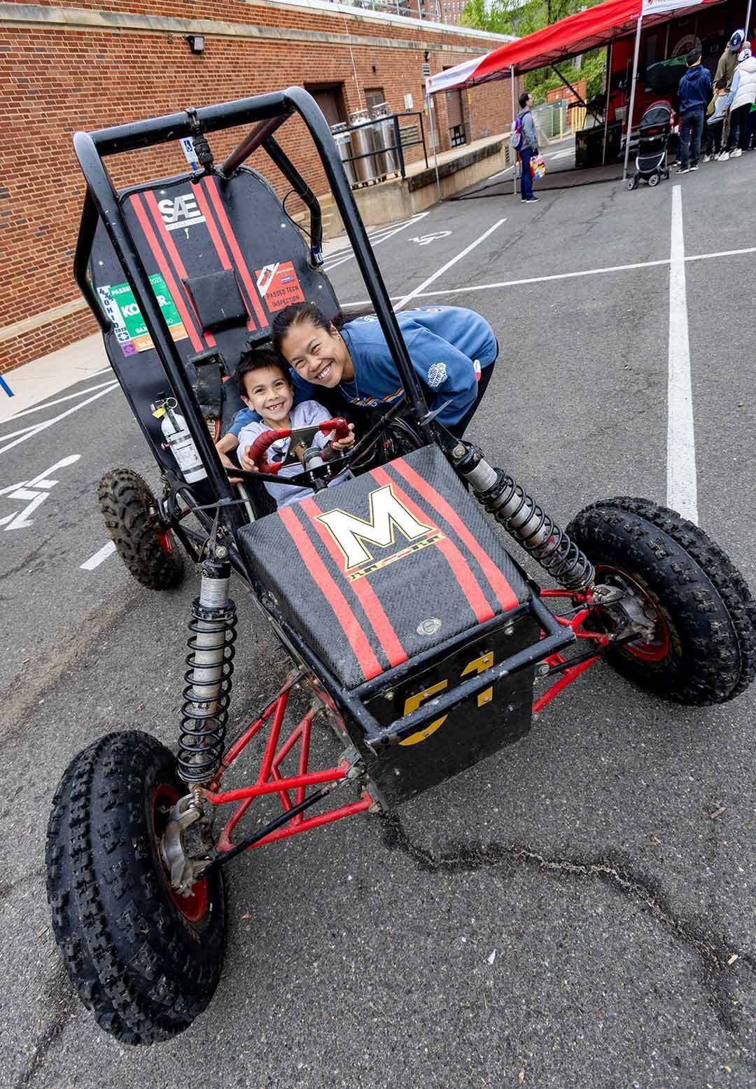 people pose in a small race car