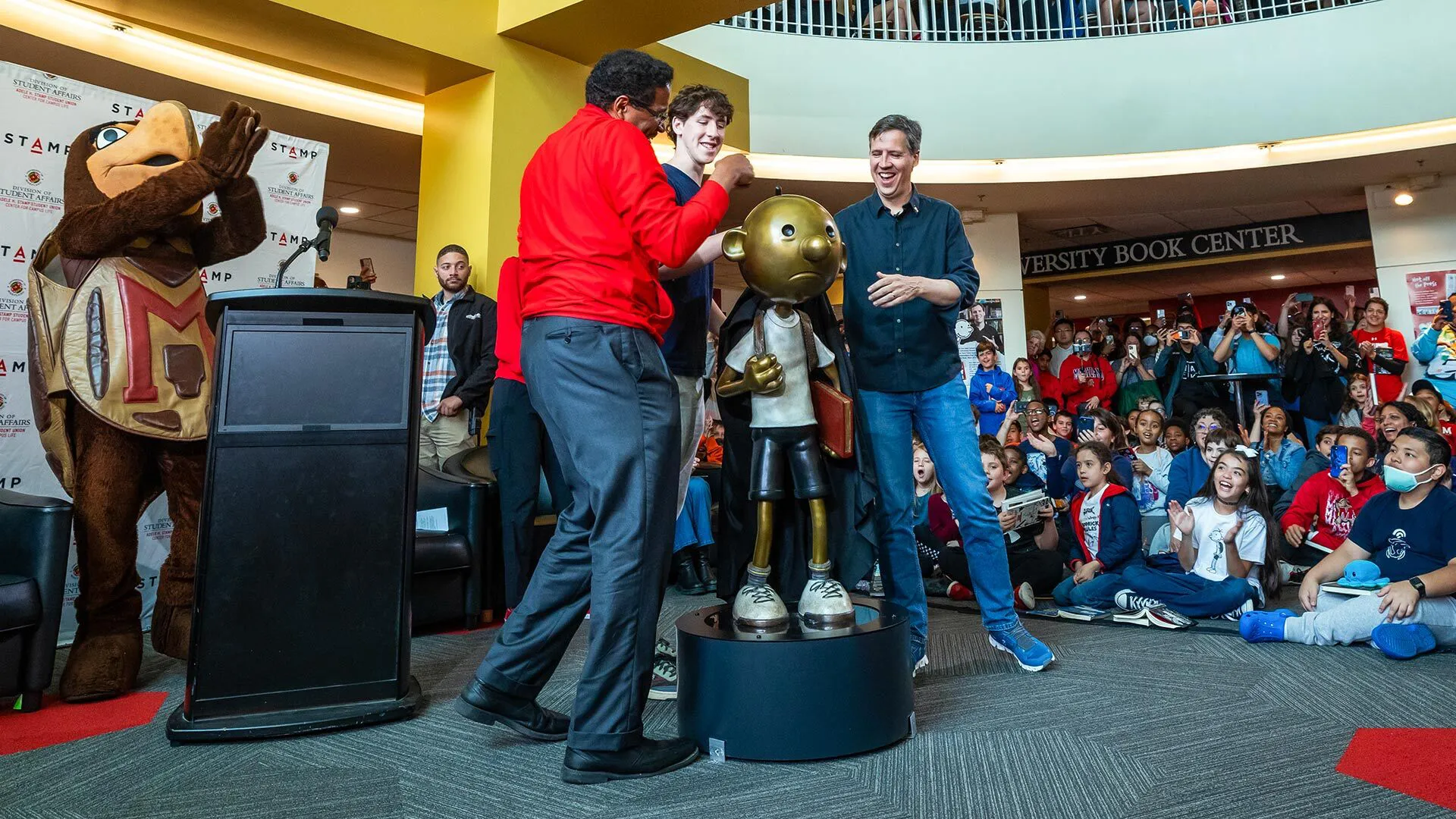 Testudo, President Darryll J. Pines and Jeff Kinney unveil the Greg Heffley "Wimpy Kid" statue in the Adele H. Stamp Student Union