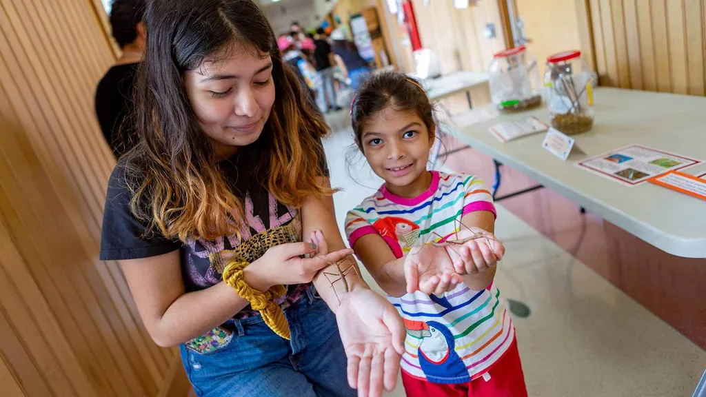 Two visitors at the insect petting zoo