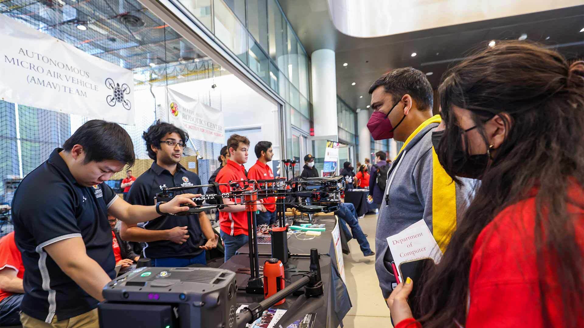 Visitors look at drones