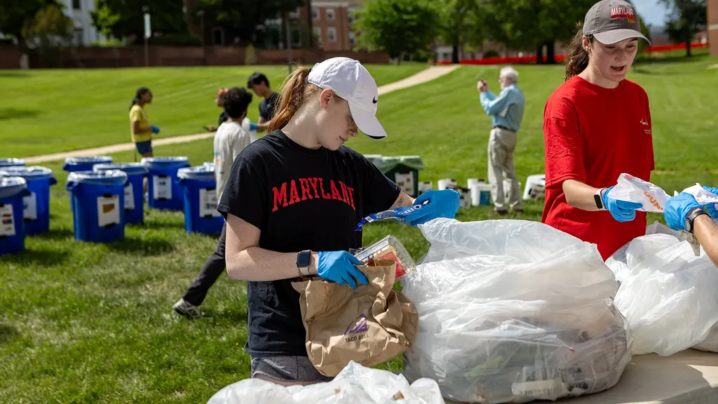 student examines bag of trash on McKeldin Mall