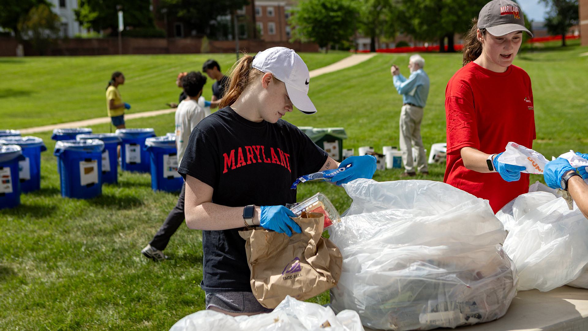 student examines bag of trash on McKeldin Mall
