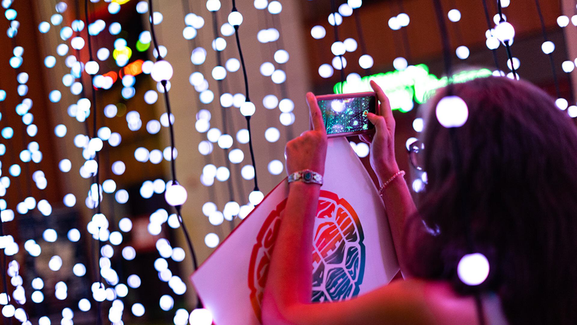 students take pictures of strung lights