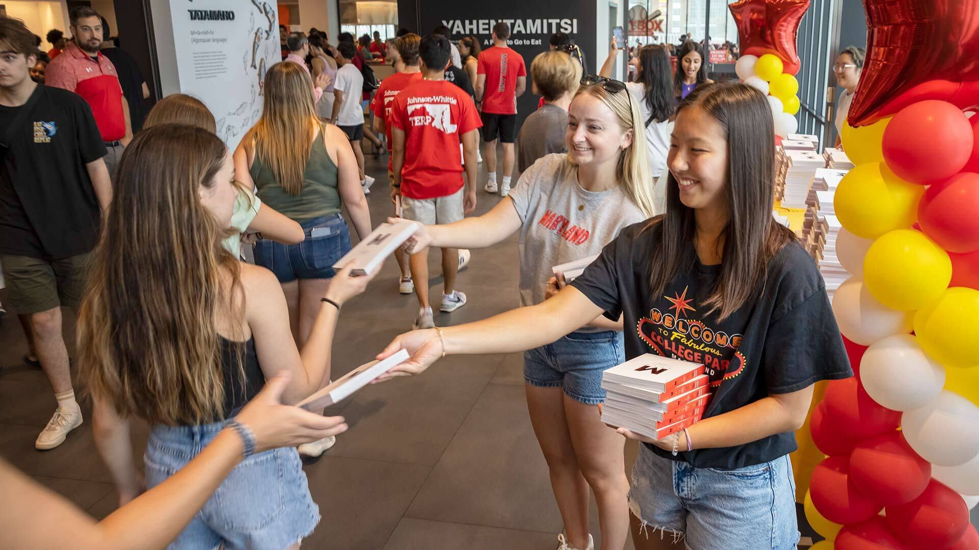 two students hand out books