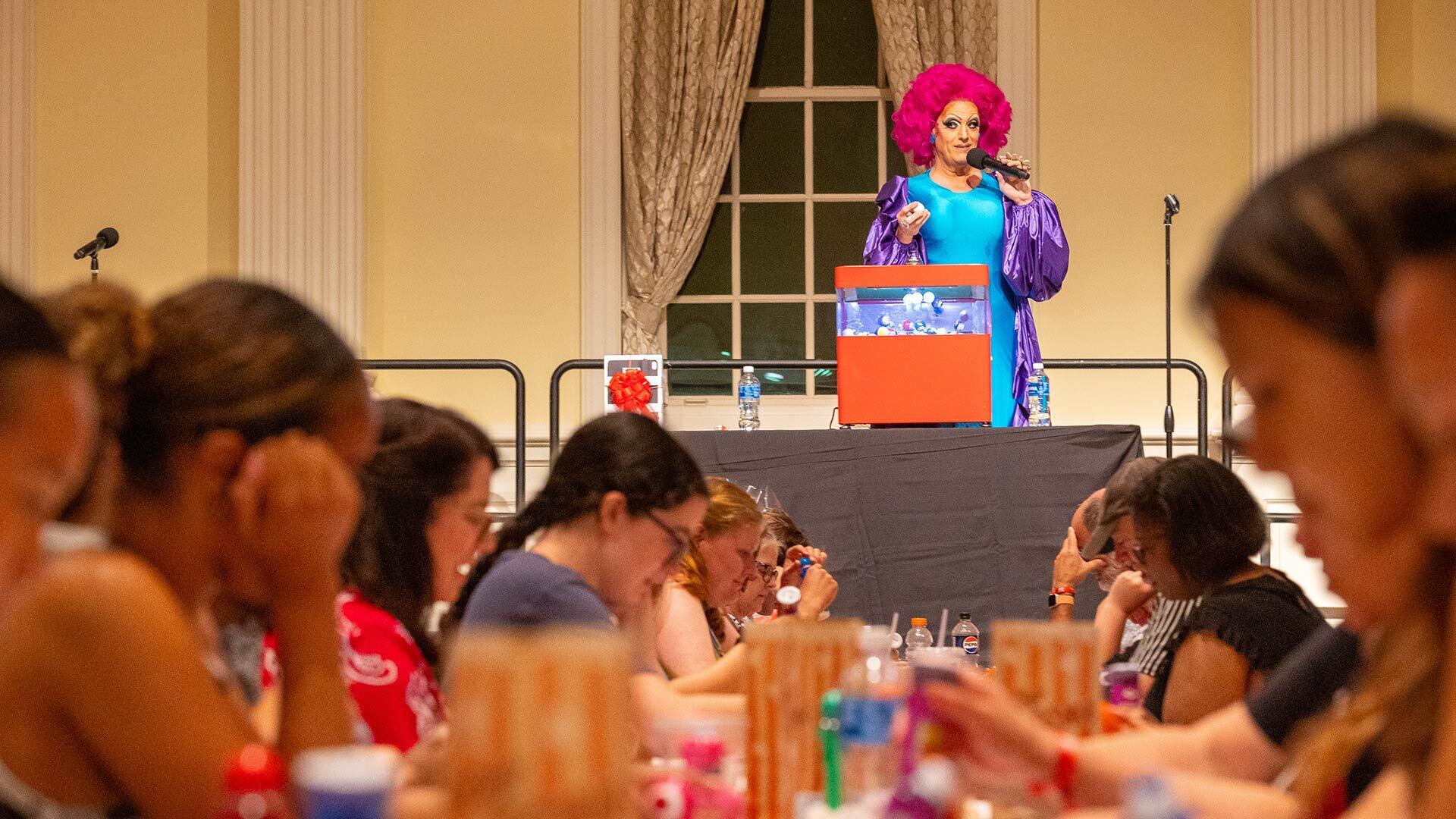 drag queen with bright red hair presides over bingo match