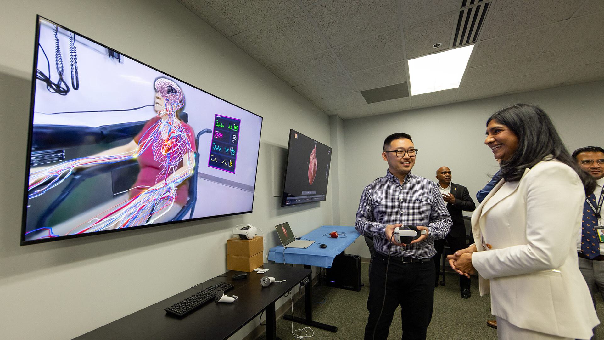 two people look at patient scenario on screen