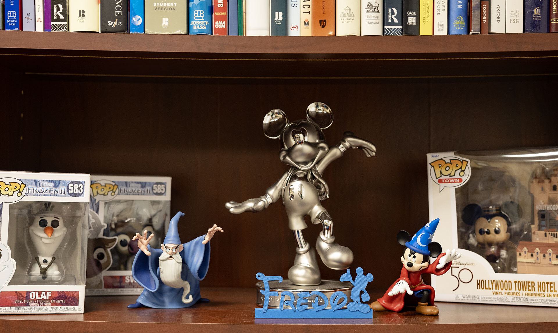 Disney figurines and "Fredo" written in Disney font