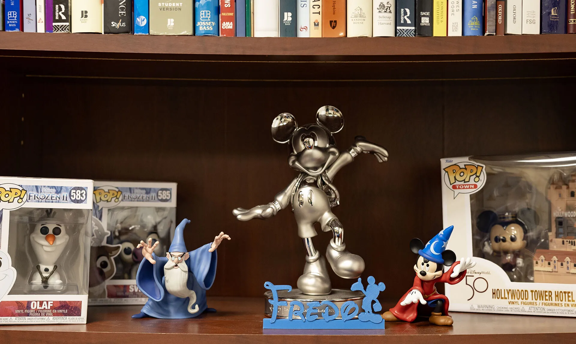 Disney figurines and "Fredo" written in Disney font