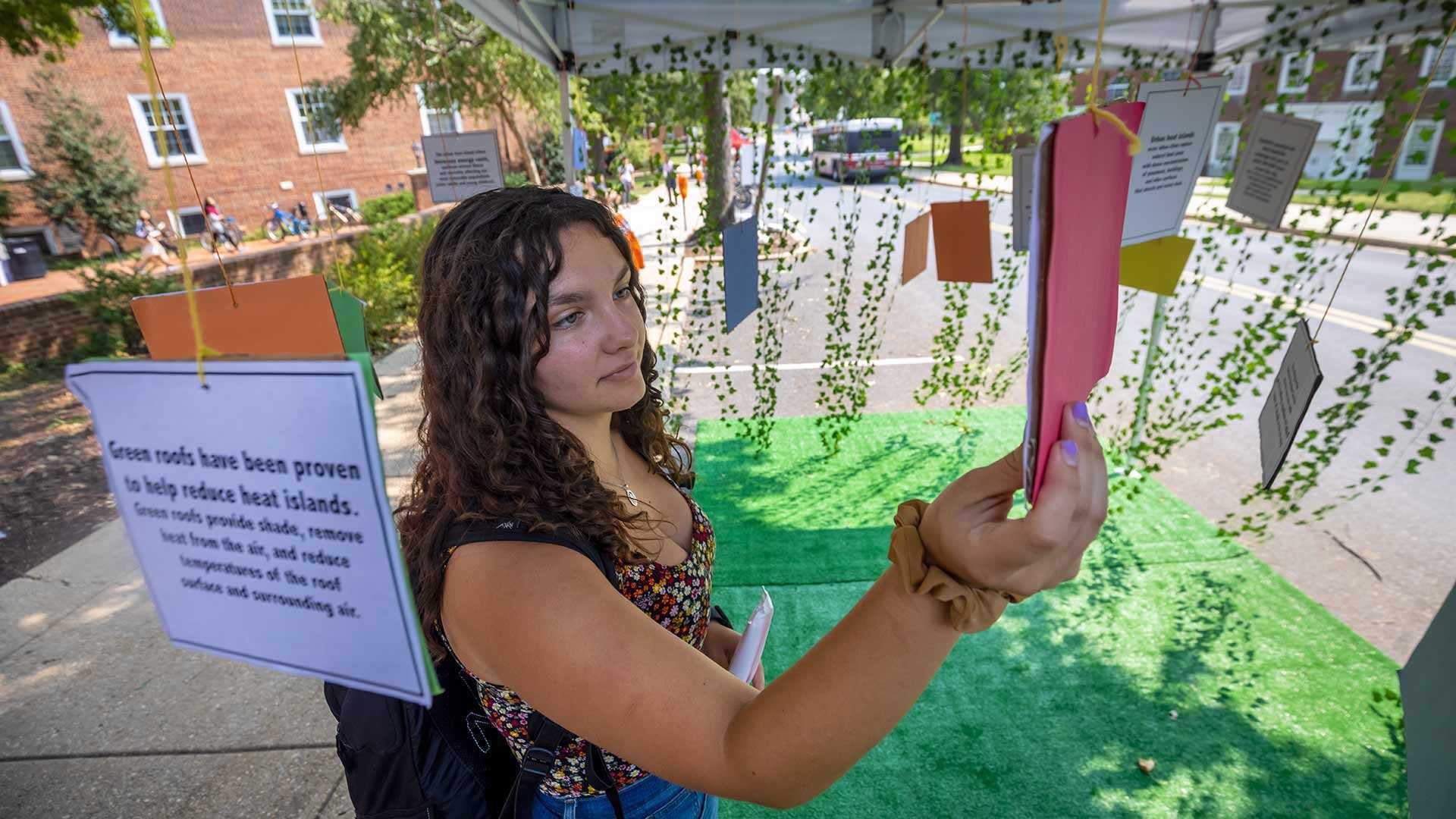 student reads info about reducing urban heat islands