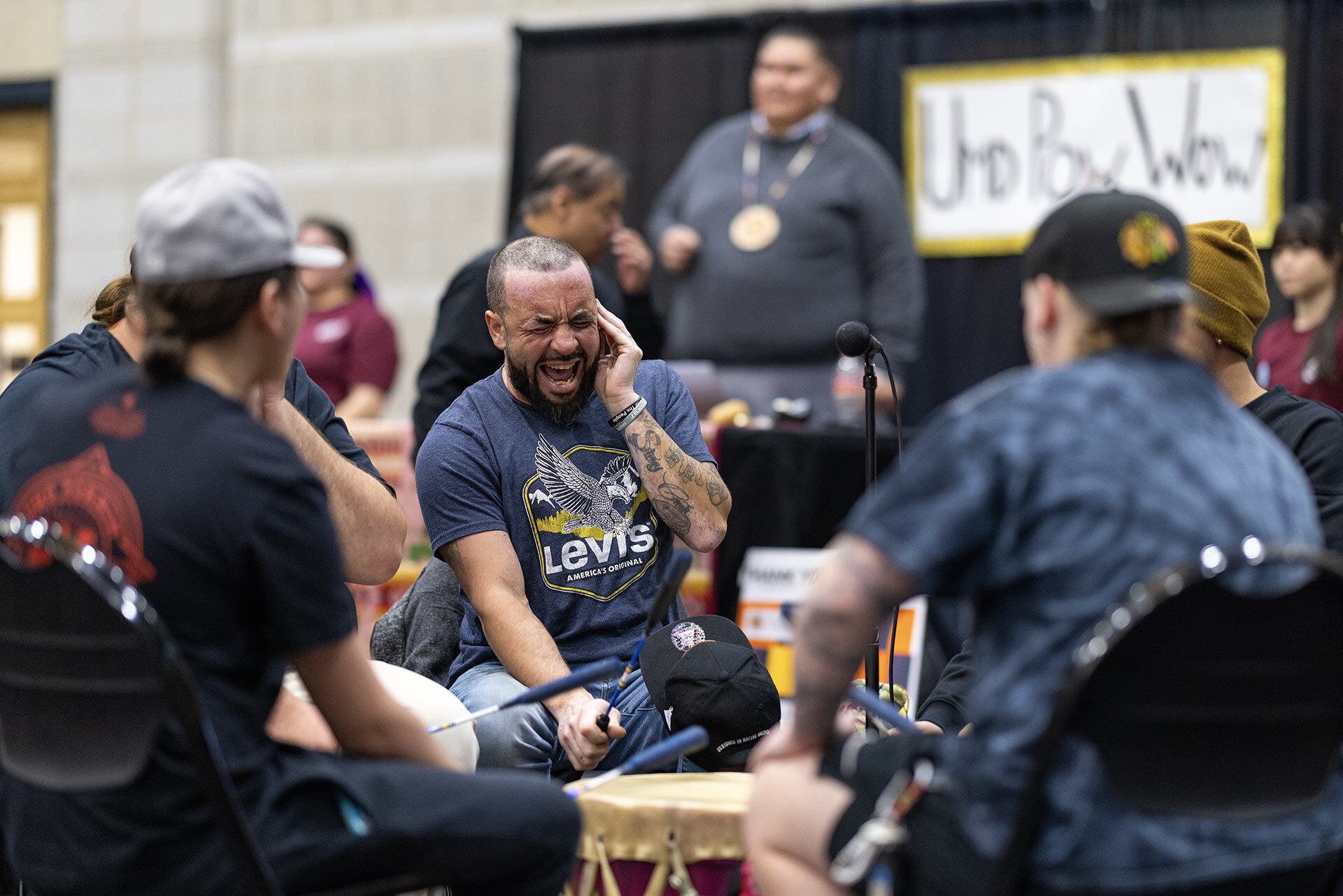 men sit in a drum circle