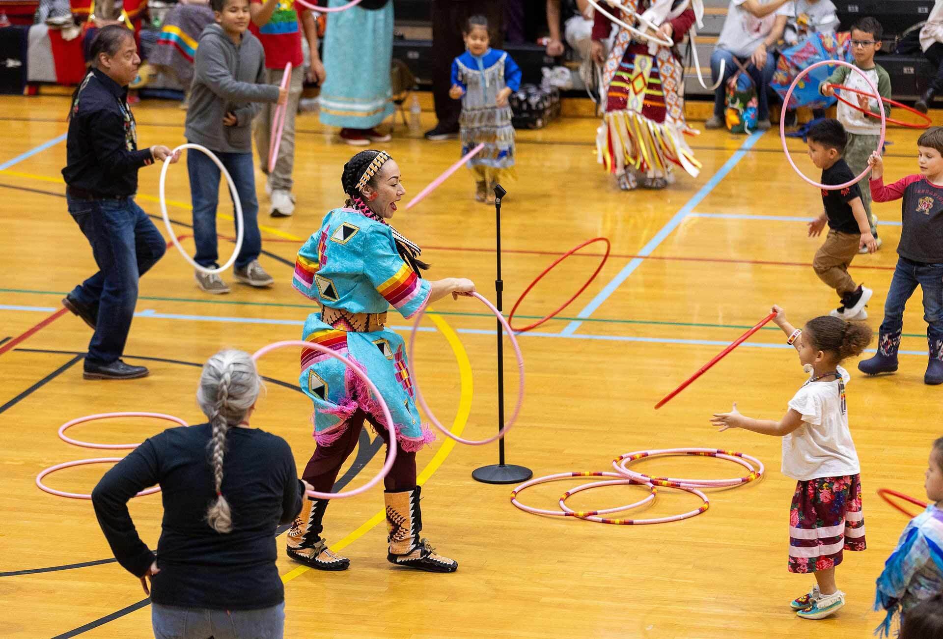 dancer in turquoise outfit does ring dance with several rings