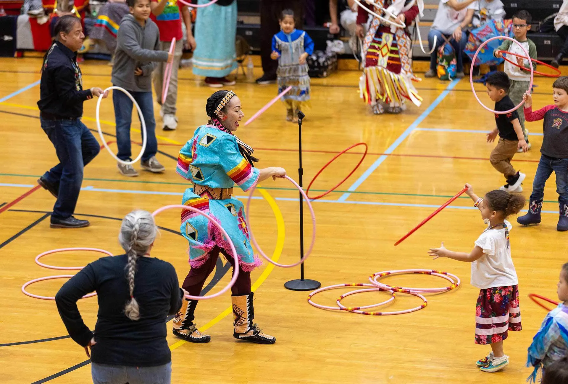 dancer in turquoise outfit does ring dance with several rings