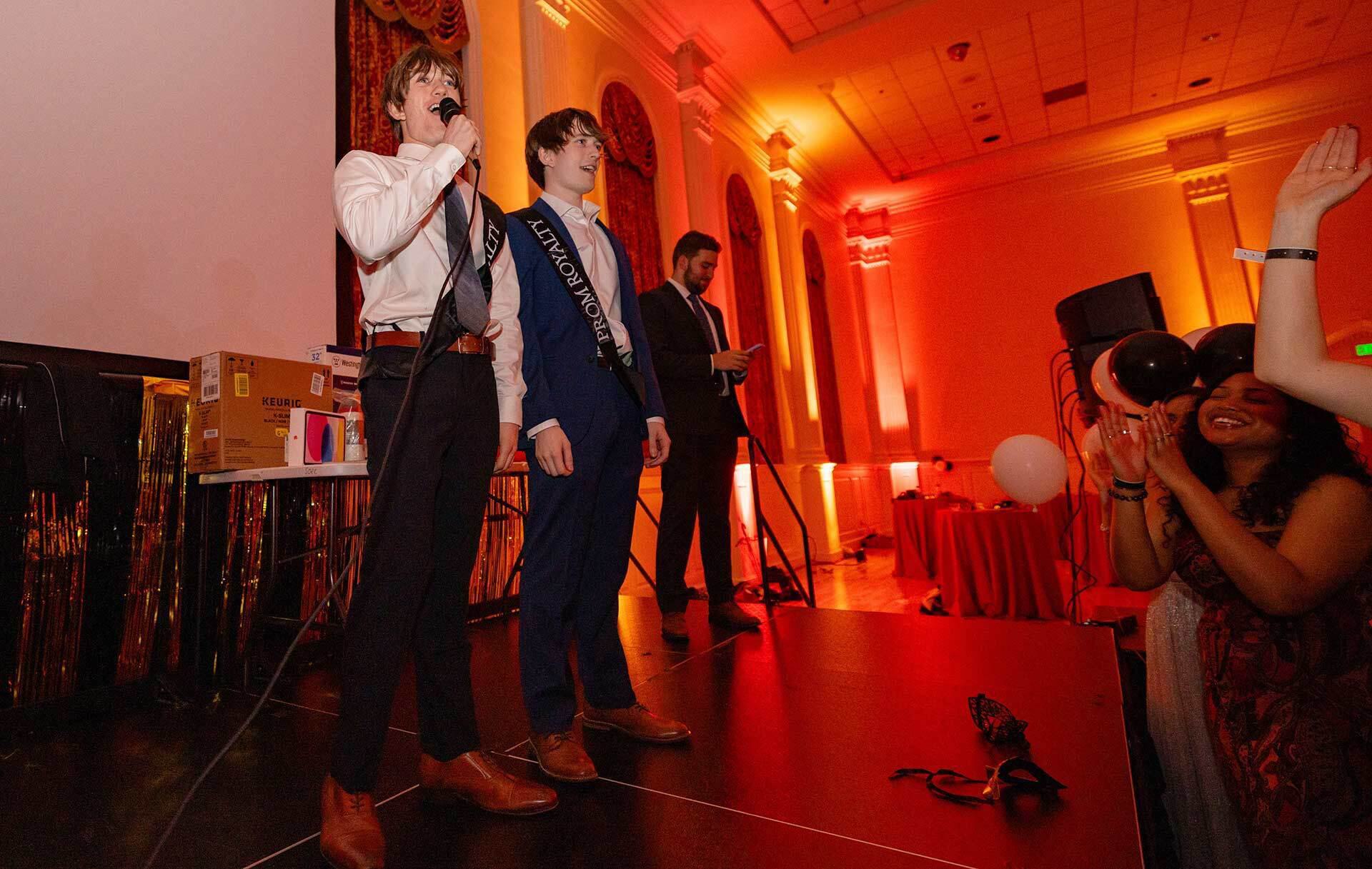 twin brothers speak to an auidience from a stage