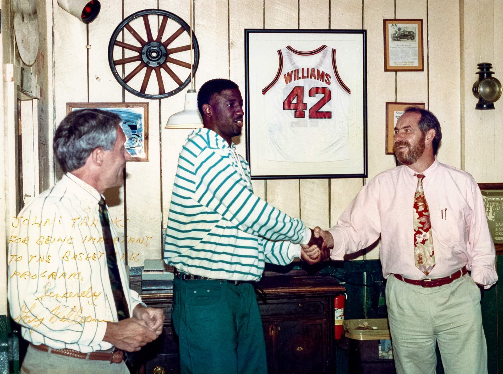 signed image of coach, player and restaurateer in office