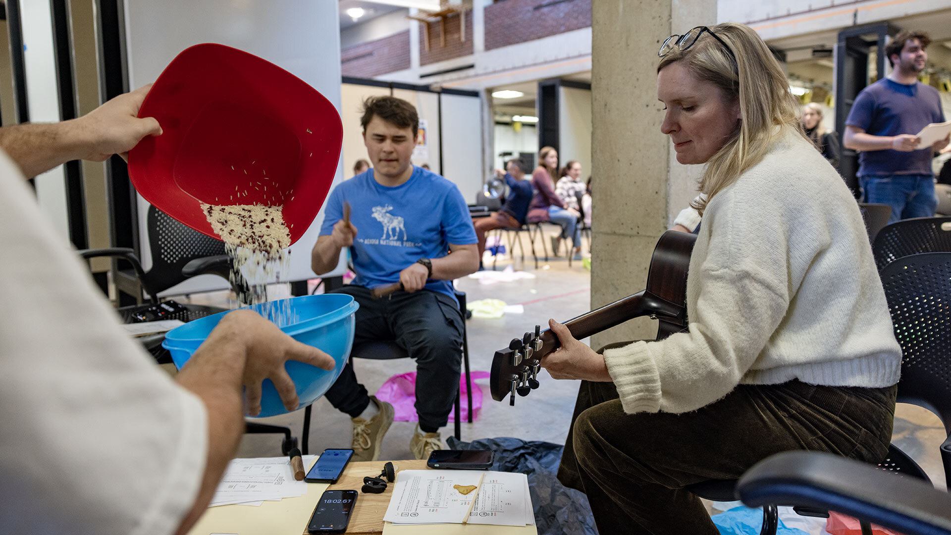musicians play guitar and pour bowl of rice