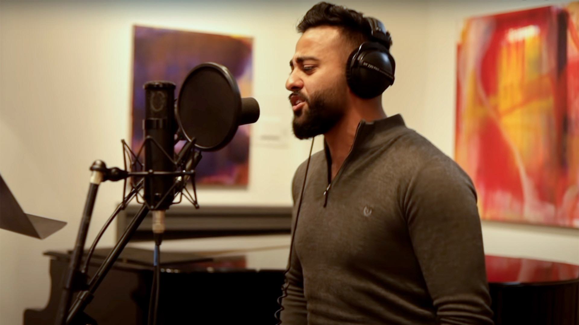 A man sings in a recording studio