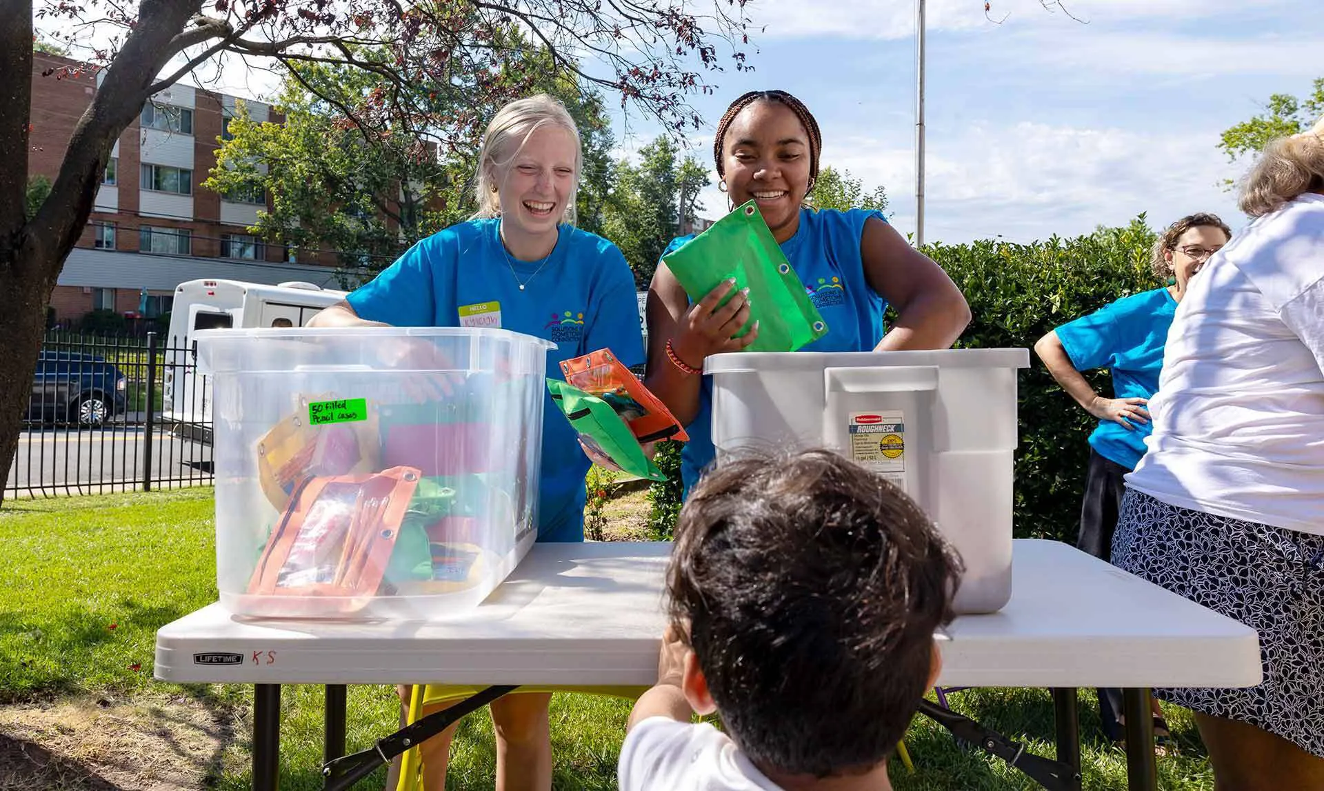 two students hand out school supplies