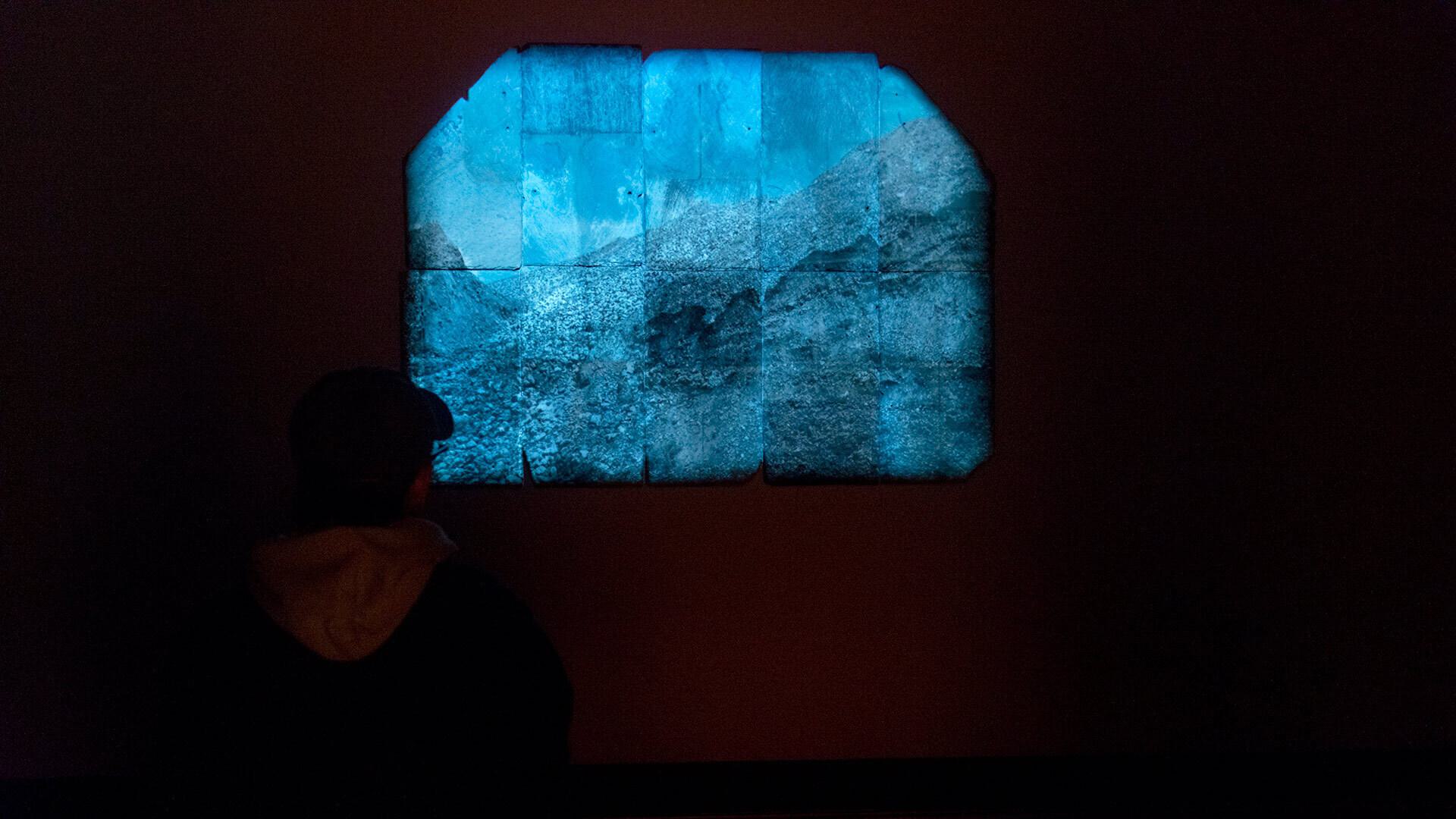 person views abstract blue “Rift” art piece