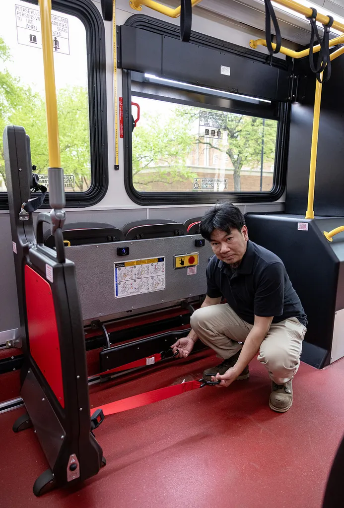 man shows wheelchair securements in Shuttle-UM bus