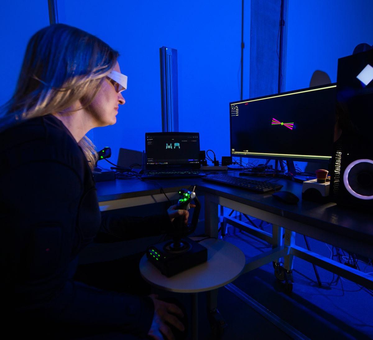 Woman wearing glasses looks at computer monitor